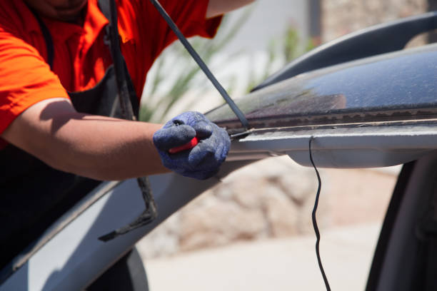 Car gets Windshield (Windscreen) replacement at owner's location. Tech has removed old glass and removes old rubber gasket before installing new glass.