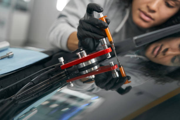 Cropped photo of car technician injecting windscreen liquid resin into damaged area