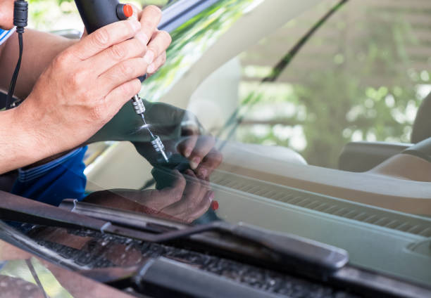 Glazier using tools repairing to fix crack windshield