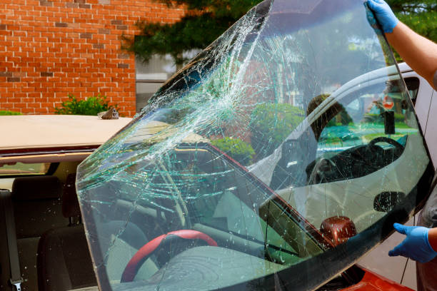 Broken windshield car special workers take of windshield of a car in auto service from inside from accident of car.