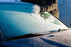 A car parked in cold weather with visible windshield chips, highlighting preventive measures and repair tips for winter.