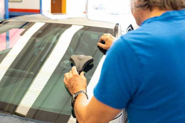 A close-up view of a windshield with a visible crack, highlighting the importance of deciding between repair or replacement for vehicle safety.