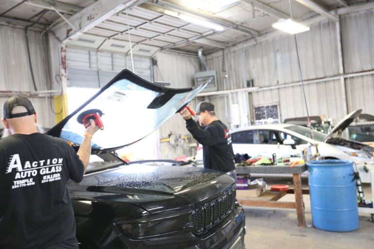 Aaction auto glass technicians installing new windshield onto black jeep