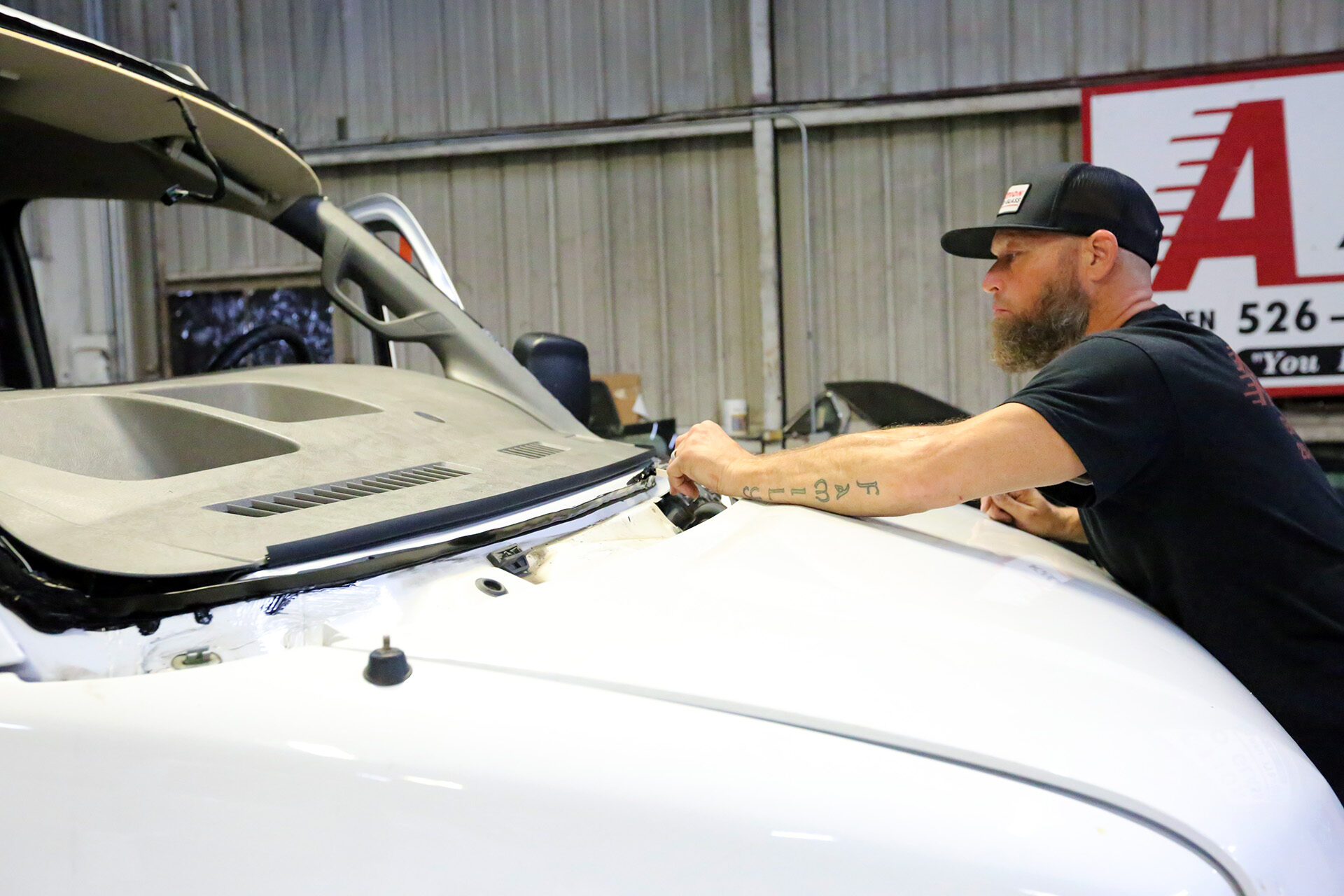 Aaction auto glass technician applying adhesive to white van windshield
